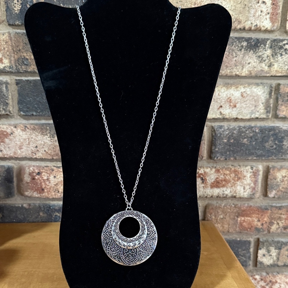 Silvertone bohemian circular necklace with an ornate floral & geometric pendant